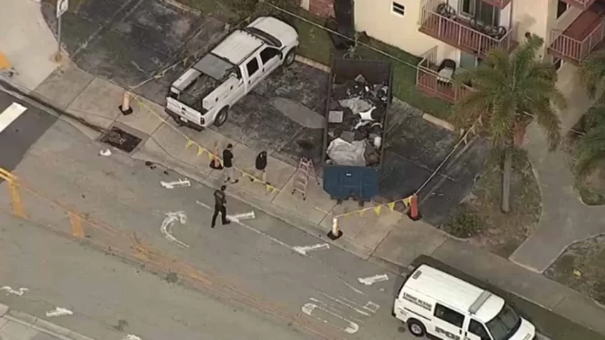 Overhead shot showing police examining a dumpster